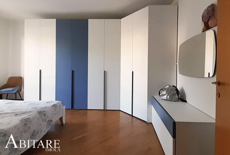 interior design arredare casa camera matrimoniale cabina arnadio angolare laminato laccato ral blu specchio angoli rotondi